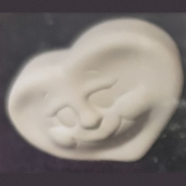 Heart face, number 61, unpainted bisque on black velvet