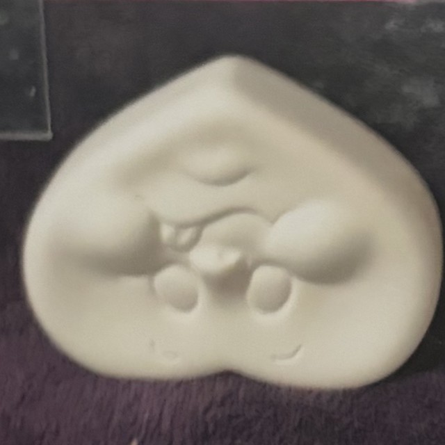 Heart face, number 62, unpainted bisque on black velvet