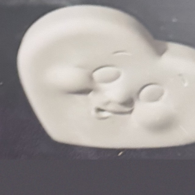 Heart face, number 64, unpainted bisque on black velvet