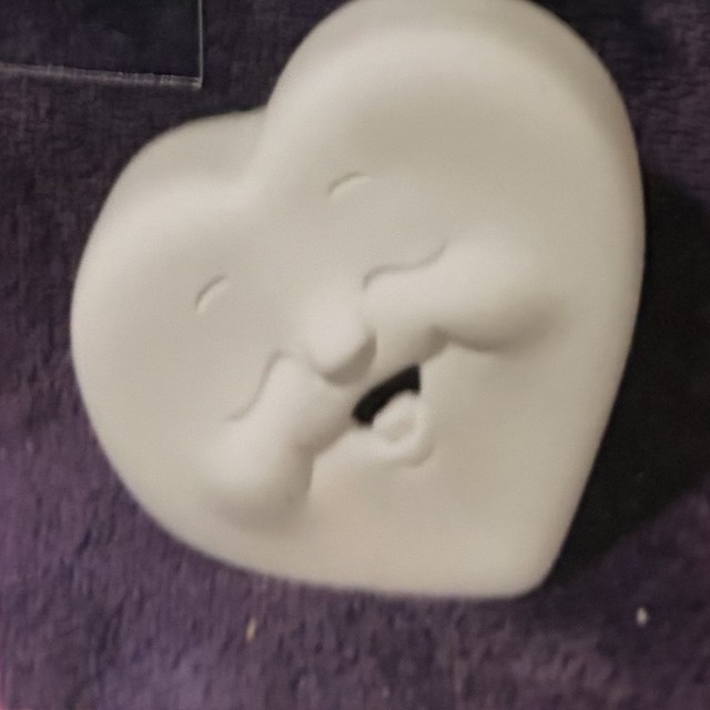 Heart face, left side, teeth, number 66, unpainted bisque on black velvet